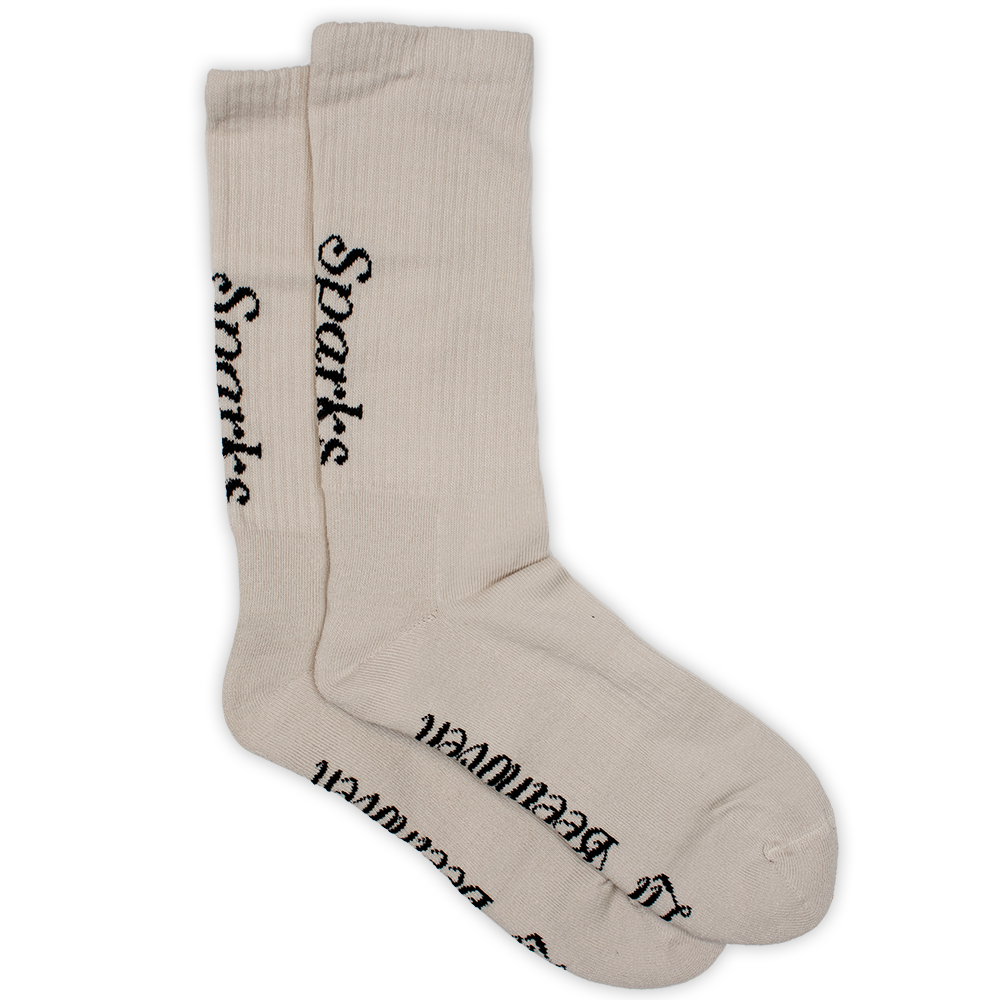 Pair of beige socks with black text printed on them.