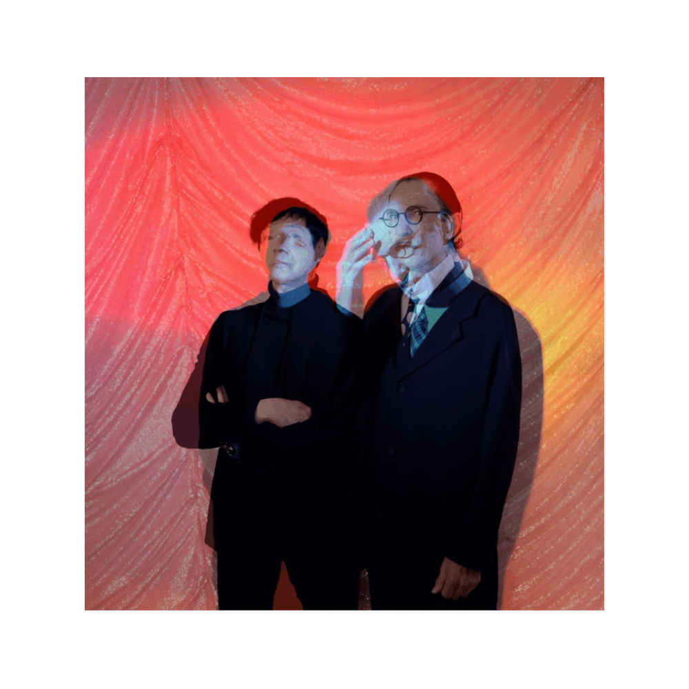 Two men standing side by side against a colorful backdrop.